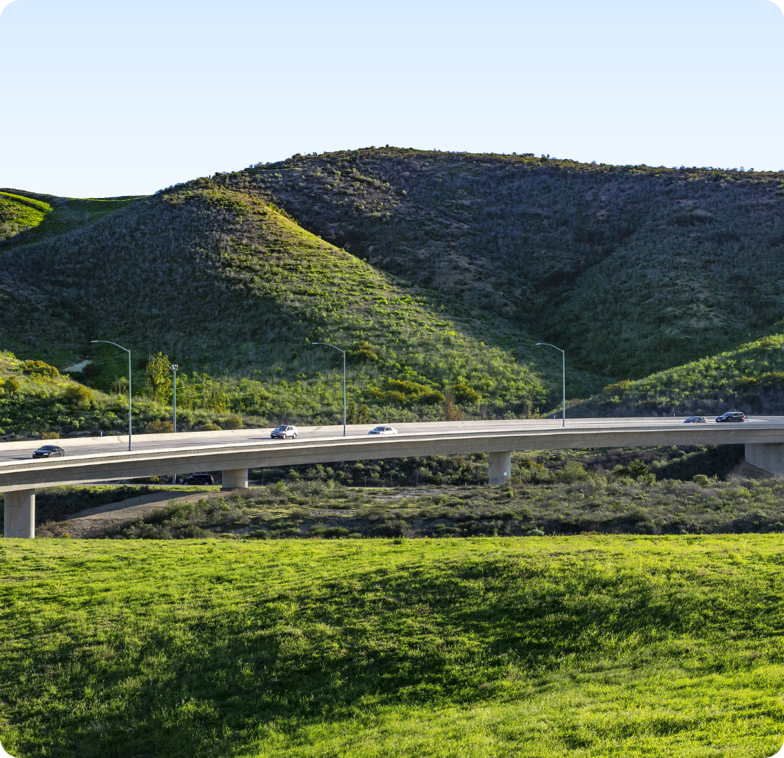 The Toll Roads surrounded by hills and green grass